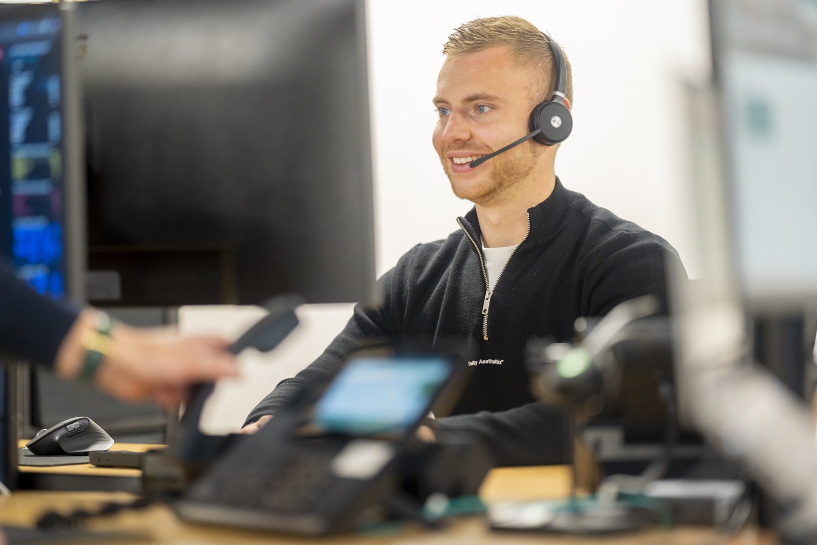 Specialist van IT-Wizzard met headset achter zijn werkplek